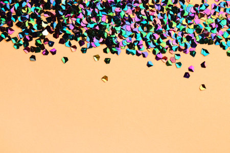 Pile of shiny glitter on beige background, space for text