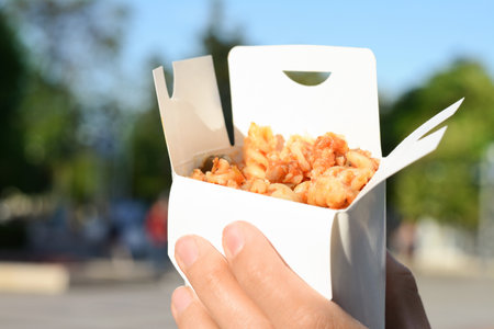 Woman holding paper box with takeaway noodles outdoors, closeup and space for text. street foodの写真素材