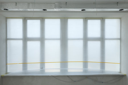 Window and sill covered by plastic film indoors