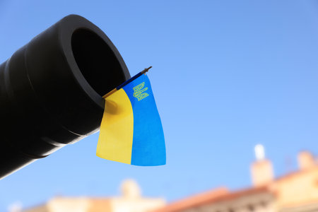 Ukrainian flag in muzzle of tank outdoors