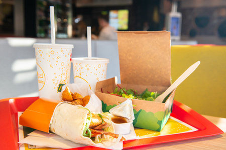 WARSAW, POLAND - SEPTEMBER 16, 2022: Big Mac hamburger, fried potatoes and cold drinks on table in McDonald's cafeのeditorial素材