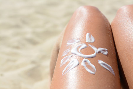 Sun drawn with sunscreen on woman's leg at beach, closeup. Space for textの写真素材