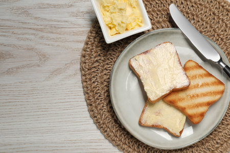 Tasty toasts with butter on white wooden table, flat lay. Space for textの写真素材