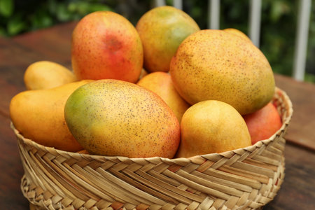 Delicious ripe juicy mangos on wooden table, closeupの写真素材