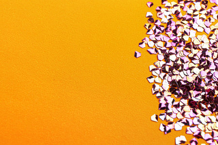 Shiny bright violet glitter on yellow background. Space for text