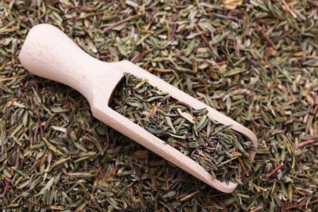 Wooden scoop with dried thyme, top view