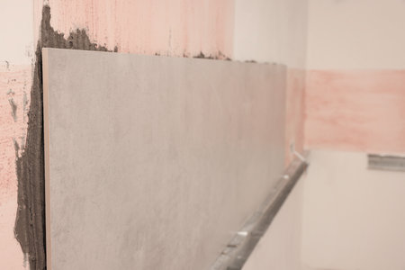 Adhesive mix and tiles on wall indoorsの写真素材