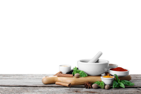 Mortar and different spices on wooden table against white background. Space for textの写真素材