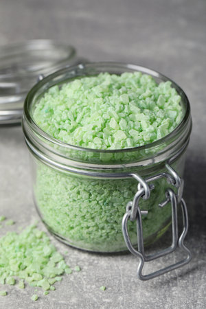 Jar with green sea salt on light gray table, closeupの写真素材