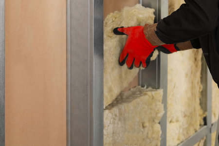 Worker installing thermal insulation material on wall, closeupの写真素材