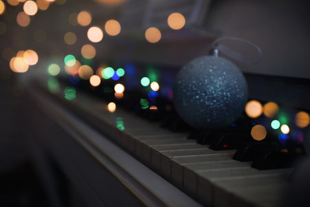 Beautiful bauble and fairy lights on piano keys, space for text. christmas musicの写真素材