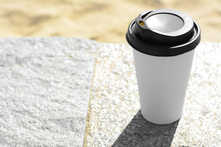 Takeaway coffee cup on stone surface outdoors. Space for textの写真素材