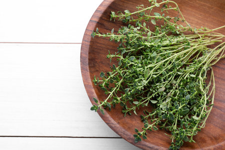 Bowl with aromatic green thyme on white wooden table, top view. Space for textの写真素材