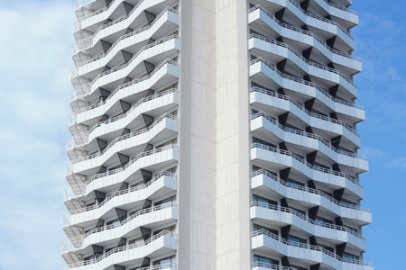 Exterior of beautiful building with balconies against blue sky, low angle view