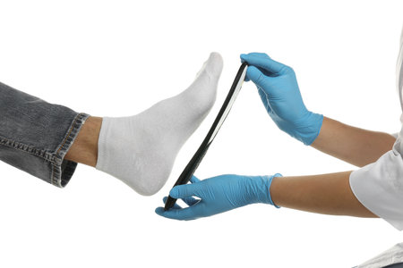 Orthopedist fitting insole to patient's foot on white background, closeupの写真素材