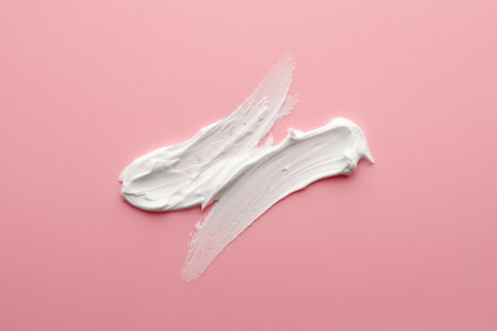 Sample facial cream on pink background, top viewの写真素材