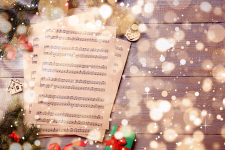 Flat lay with Christmas music sheets on wooden background, space for textの写真素材