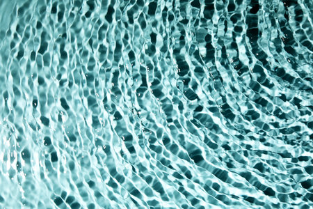 Close up view of water with rippled surface on light blue backgroundの写真素材