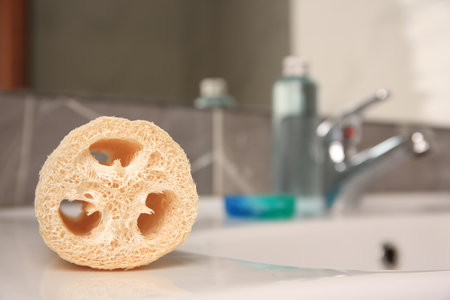 Loofah sponge on sink in bathroom, closeup. Space for textの写真素材