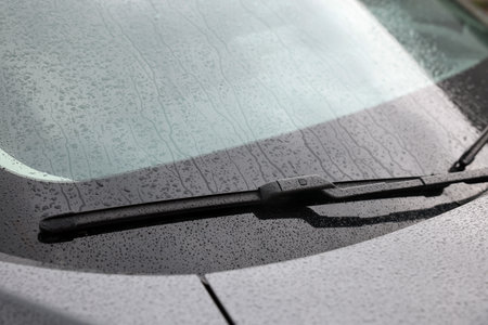 Car wiper cleaning water drops from windshield glass, closeupの写真素材