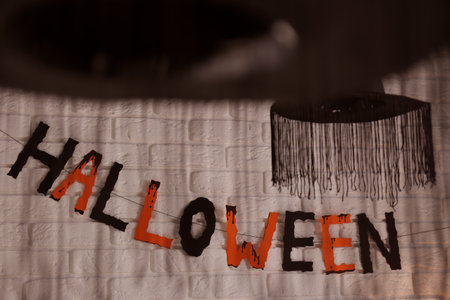 Word Halloween made of colorful letters and festive decor on brick wallの写真素材