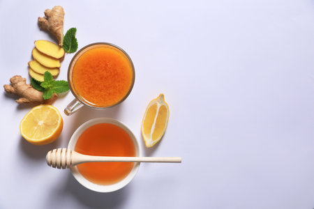 Delicious ginger tea and ingredients on white background, flat lay. Space for textの写真素材
