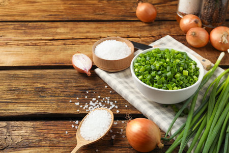 Chopped green onion in bowl on wooden table, space for textの写真素材