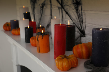 Candles and pumpkins on fireplace indoors, closeup. halloween decorの写真素材