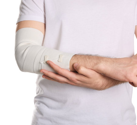 Man with arm wrapped in medical bandage on white background, closeupの写真素材