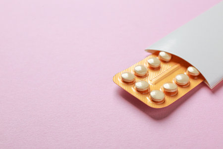 Birth control pills on pink background. Space for textの写真素材