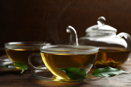 Fresh green tea in glass cups, leaves and teapot on wooden table, closeupの写真素材