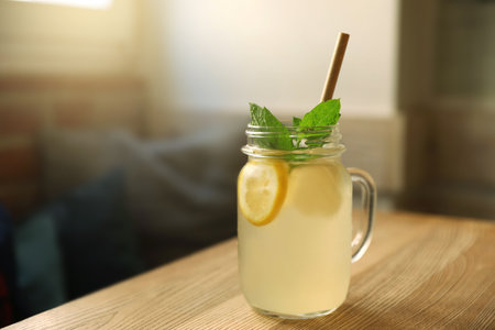 Delicious lemonade with mint in mason jar on wooden table indoors, space for text. Refreshing drinksの写真素材