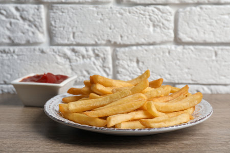 Tasty french fries served with ketchup on wooden tableの写真素材