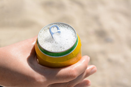 Woman holding can with sparkling drink at beach, closeupの写真素材