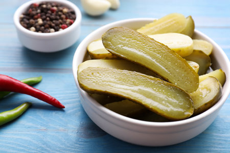 Pickled cucumbers and spices on light blue wooden table, closeupの写真素材