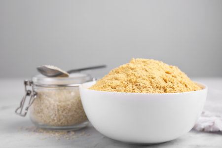 Sesame flour in ceramic bowl on white marble tableの写真素材
