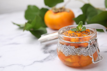 Delicious dessert with persimmon and chia seeds on table. Space for textの写真素材