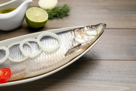 Delicious salted herring and ingredients on wooden table, closeupの写真素材