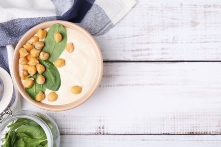 Tasty chickpea soup in bowl on white wooden table, flat lay. Space for textの写真素材
