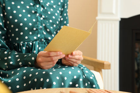 Woman holding greeting card in living room, closeup