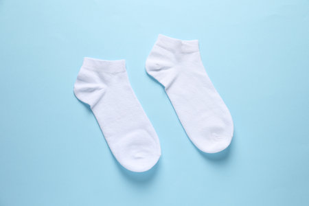 Pair of white socks on light blue background, flat layの写真素材