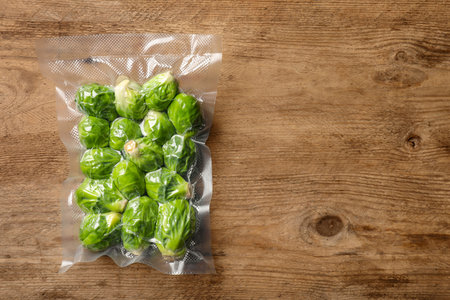 Vacuum pack of Brussels sprouts on wooden table, top viewの写真素材