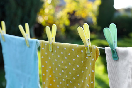 Clean clothes drying in garden, focus on clothespin