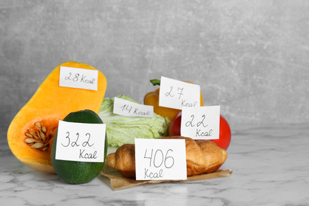 Food products with calorific value tags on white marble table. weight loss conceptの写真素材