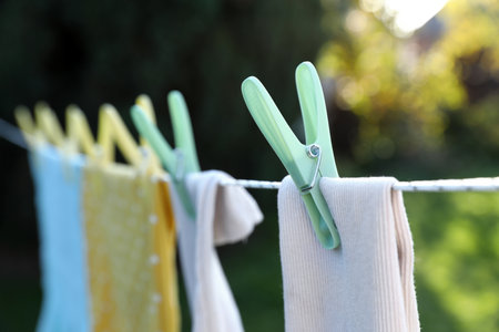 Clean clothes drying in garden, focus on clothespinの写真素材