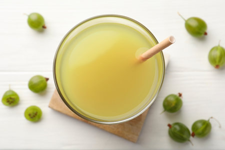 Tasty gooseberry juice on white wooden table, flat layの写真素材