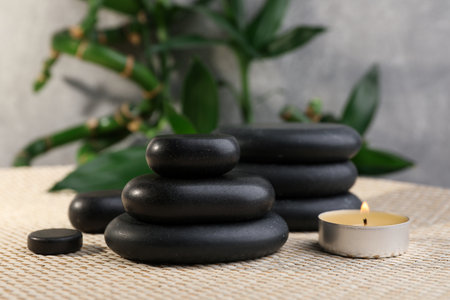Stacked spa stones, bamboo and candle on wicker matの写真素材