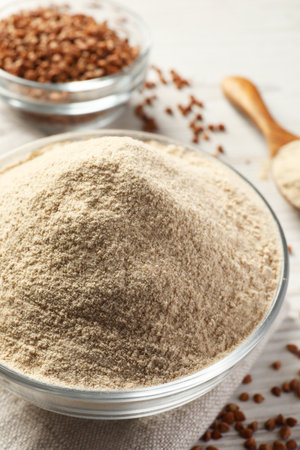Glass bowl of buckwheat flour and cloth on white table, closeupの写真素材