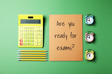 Flat lay composition with question Are you ready for exams, alarm clocks , calculator and pencils on green backgroundの写真素材