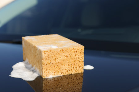 Soapy sponge on car hood. cleaning productの写真素材